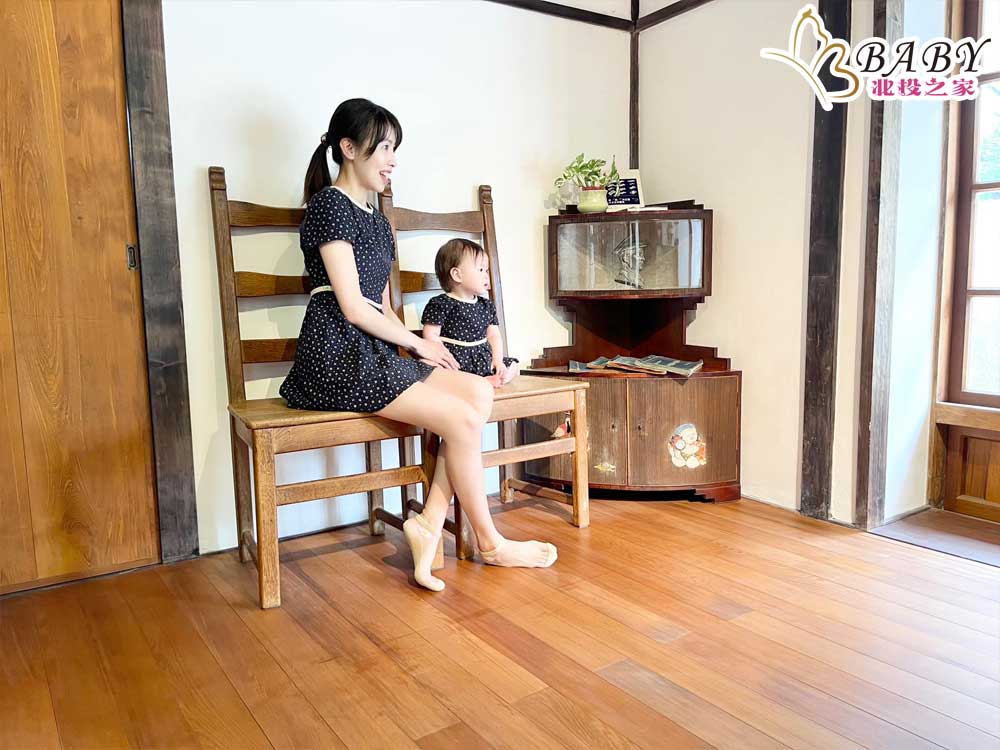 在台南水交社文化園區的櫃子前，母女倆望著同一方向，與櫃子裡的頭像互動。