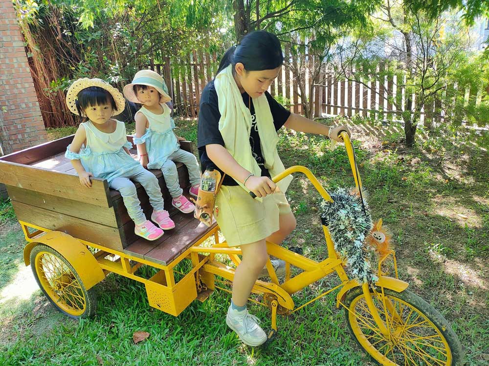 桃園觀音林家古厝休閒農場-古老與現代的完美結合,絕美景點打卡|雙寶甜妞|北投之家推薦桃園景點|北投之家 桃園觀音林家古厝休閒農場|古老與現代的完美結合,絕美景點打卡02
位於桃園觀音的林家古厝休閒農場,除了美麗的景色之外,還提供了各種適合全家大小一起參與的活動。二姐騎著三輪車帶著雙寶甜妞在農場中遊覽,這種獨特的體驗讓小朋友們在歡樂的同時,也能親近並了解到農場的日常運作。